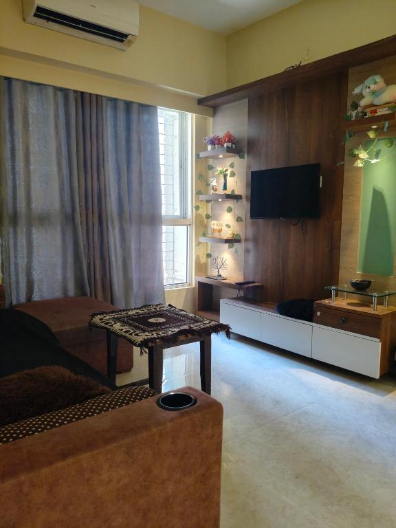 a living room with a couch and a tv at Staycation Couple friendly House in Thane