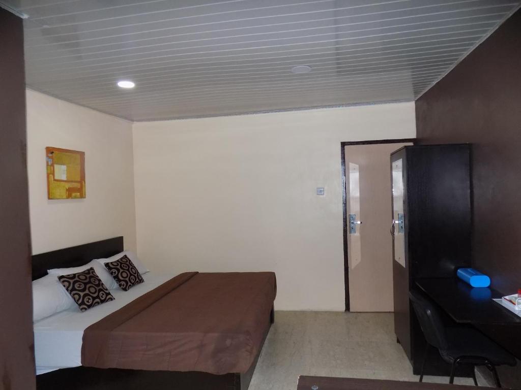 ein Schlafzimmer mit einem Bett und einem Schreibtisch. in der Unterkunft Posh Apartments and Hotel in Ikeja