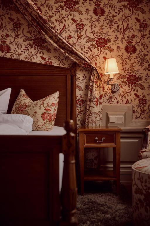 a bedroom with a bed and a table with a lamp at Hotel Detmolder Hof in Detmold