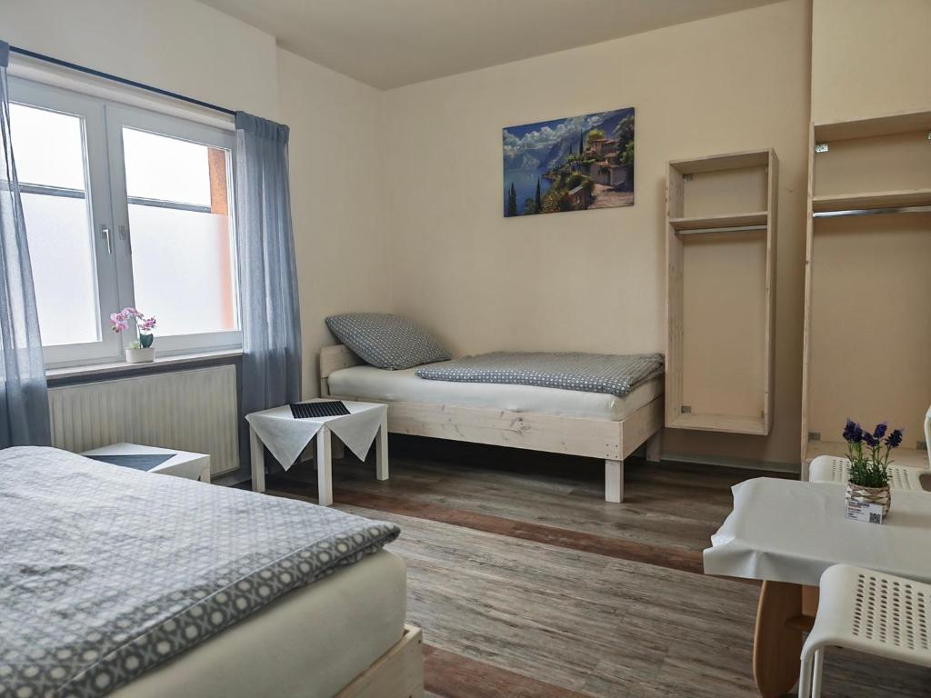 a bedroom with two beds and a window at Pension Highway - Osnabrück Klarastr 11 in Osnabrück
