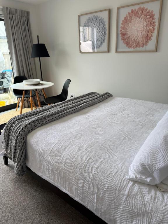 a bedroom with a bed and a table and chairs at Cozy Pakura Pad in Te Awamutu