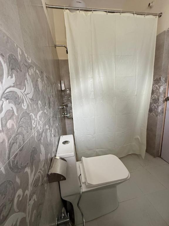 a bathroom with a toilet and a shower at Mandola Stays in Chamoli