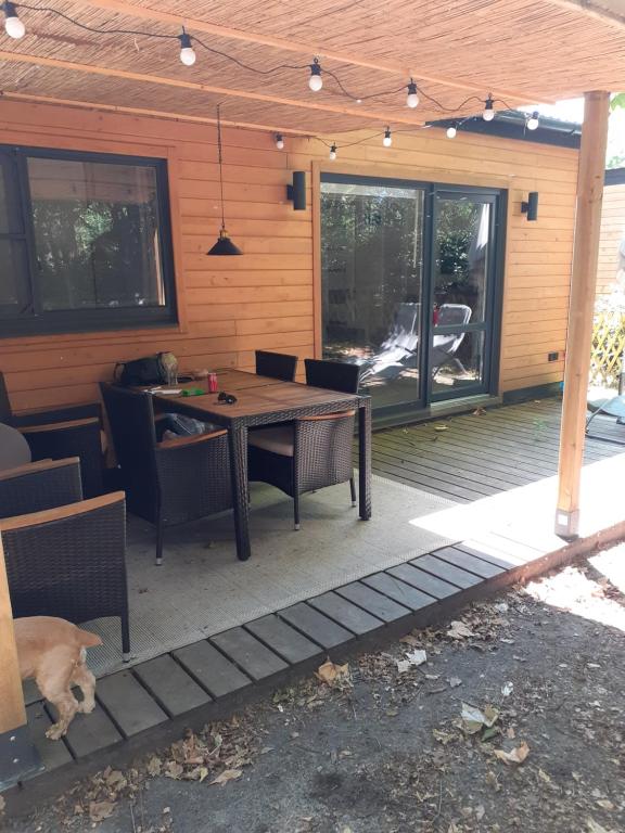 a patio with a table and chairs on a deck at Chalet dans le camping l'Orée des Landes à Onesse et Laharie in Onesse-et-Laharie