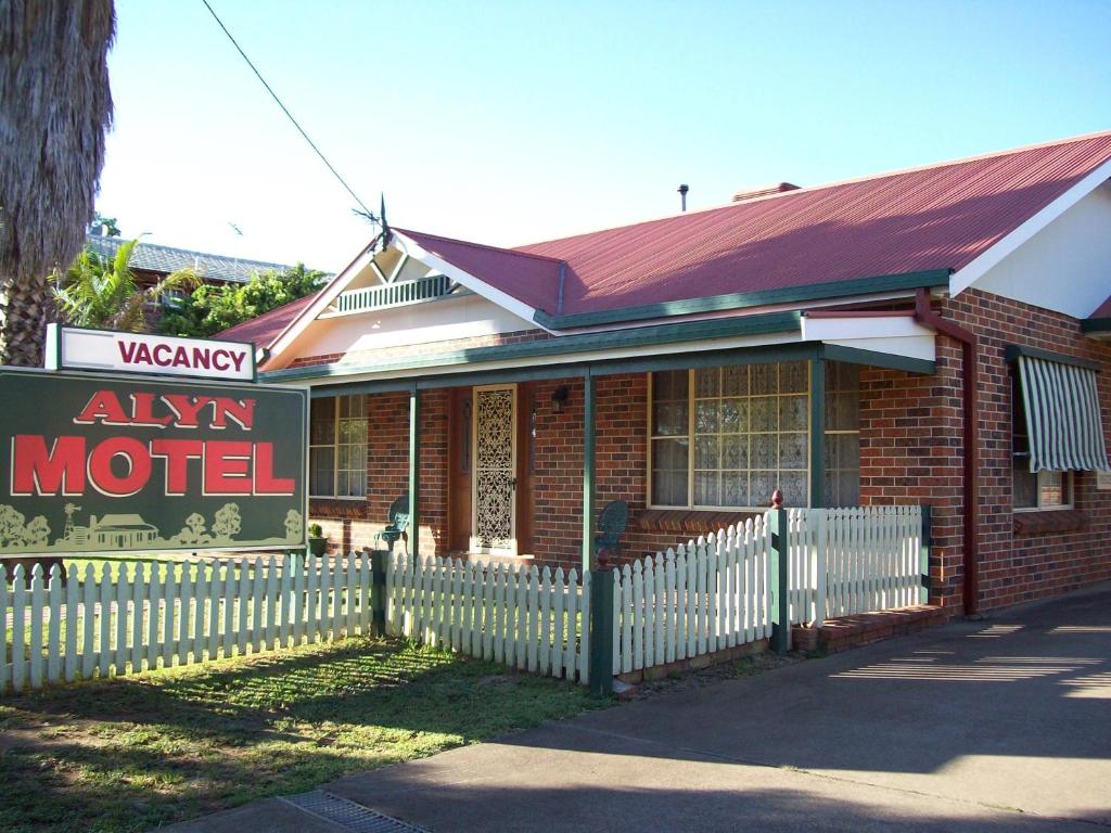 un vecchio edificio in mattoni con un cartello per un motel di Alyn Motel a Gunnedah