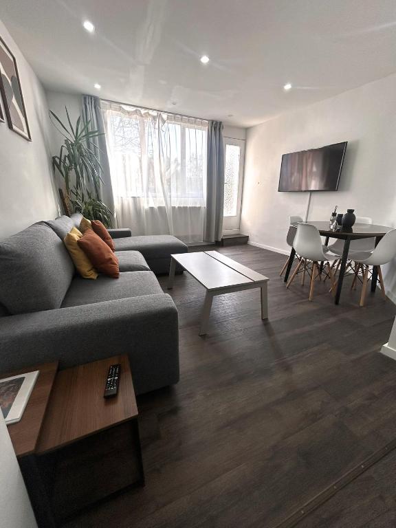 a living room with a couch and a table at Appartement cosy à 5 min du centre-ville in Liège
