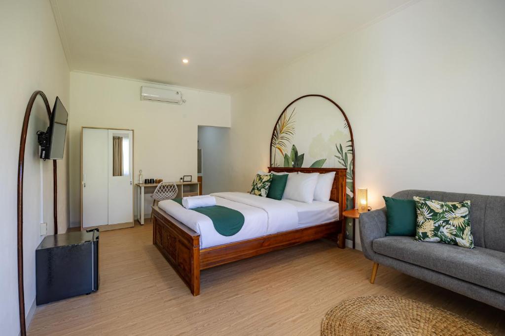 a bedroom with a bed and a couch at Cove Dahayu Sanctuary in Sanur