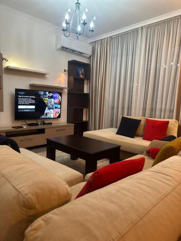 a living room with two couches and a tv at Iceland Apartment in Tirana