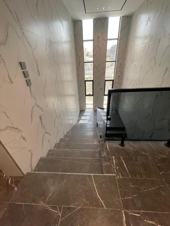 a staircase in a building with a marble wall at قوت in Abha