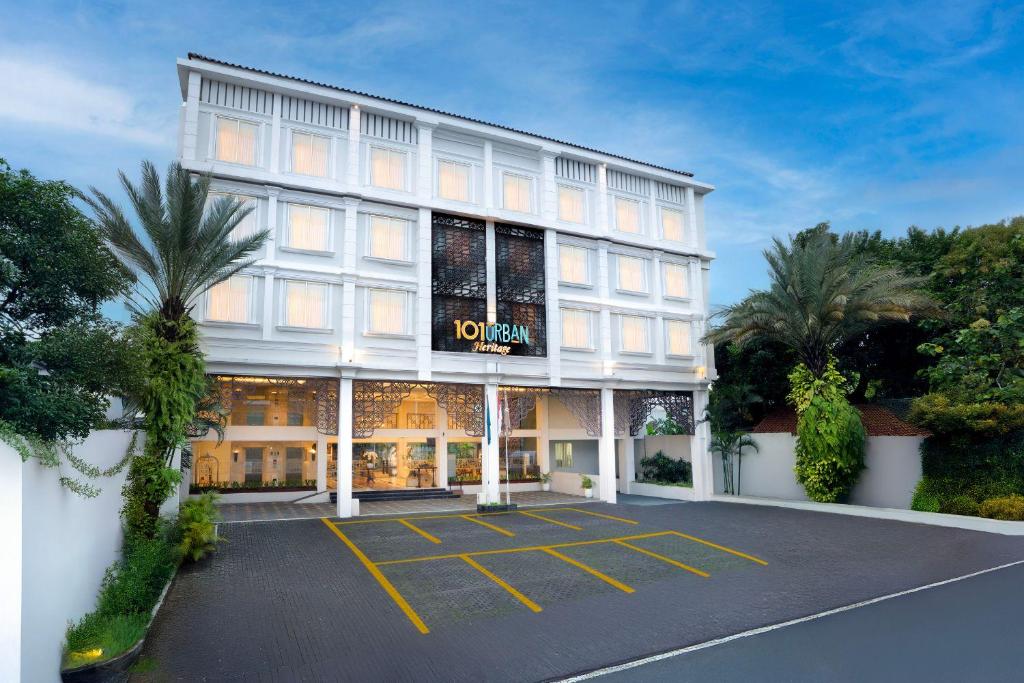 a hotel with a parking lot in front of it at 1O1 URBAN Heritage Yogyakarta Lynn Prawirotaman in Yogyakarta