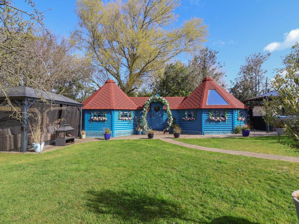 a blue house with a red roof at Applejacks Orchard in Holywell