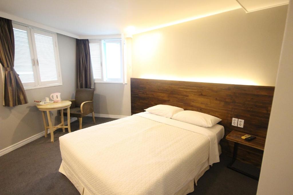 a hotel room with a bed and a table and window at Hotel Ocean View in Ulsan