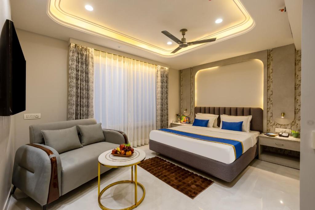 a hotel room with a bed and a couch at Hotel Anu Plaza - Newly Built Hotel With Parking Just 6 Mins from Connaught Place ,New Delhi Railway Station & Metro Station in New Delhi