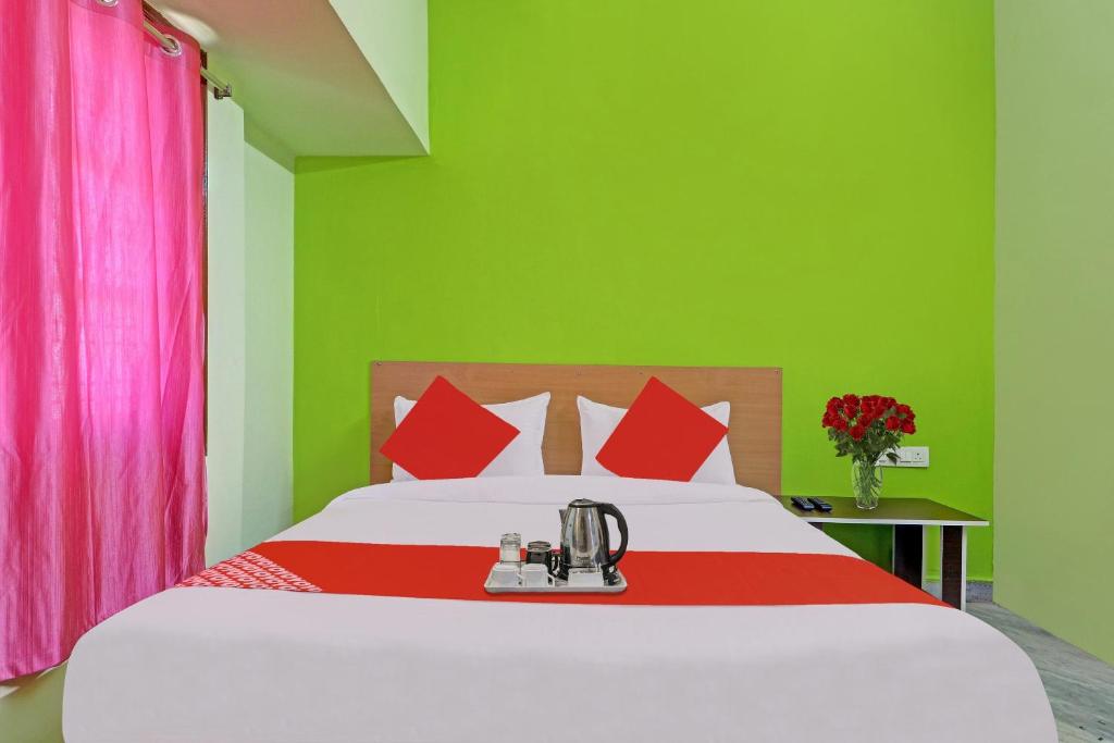 a bedroom with a bed with red and green walls at Hotel O Ss Delight in Hyderabad