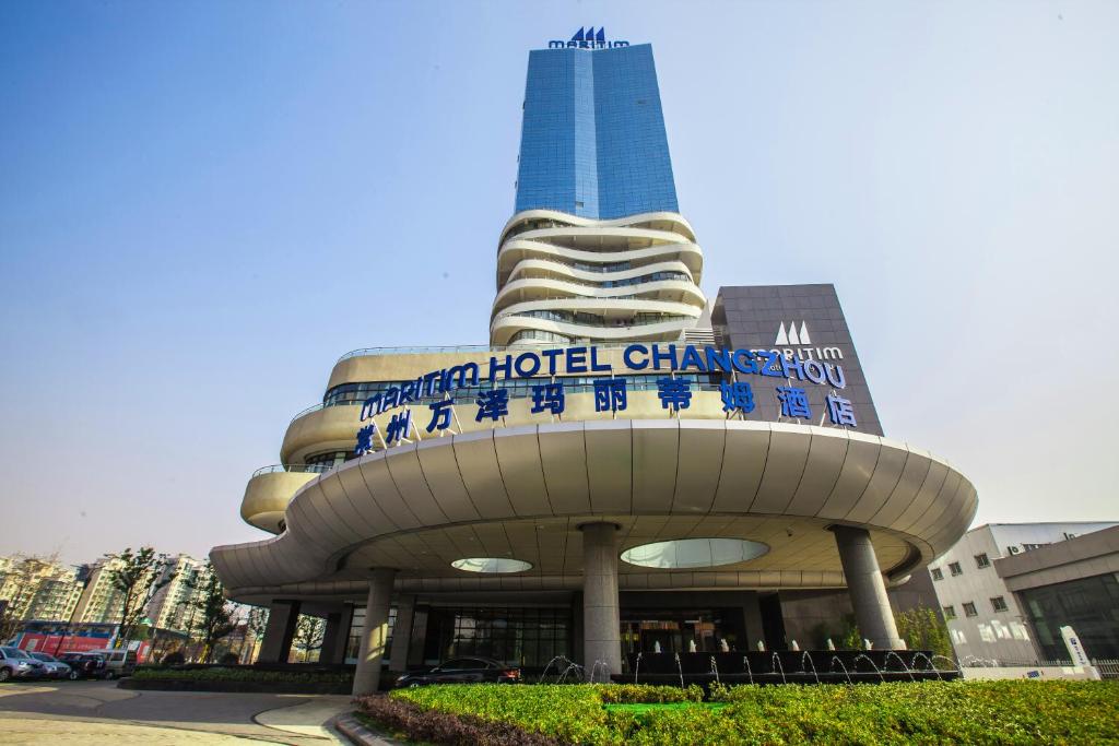 a building with a skyscraper in the background at Maritim Hotel Changzhou in Changzhou