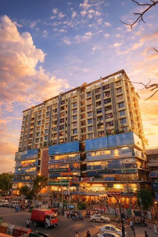 a large building with a lot of cars in a parking lot at Hotel Labbaik Three College Gate in Dhaka