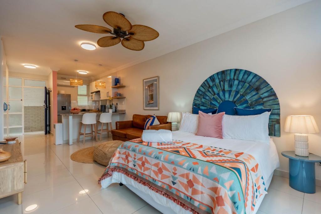 a bedroom with a large bed and a living room at Alfomada in Umdloti