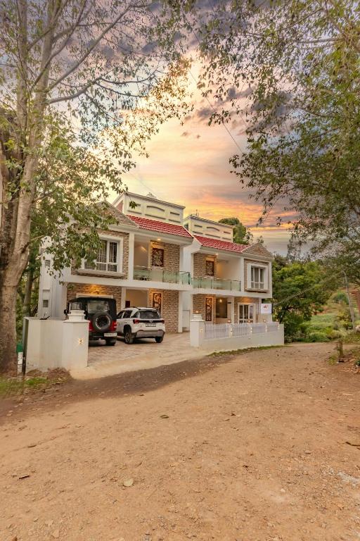 a house with a car parked in front of it at Riyan Valley Resort in Ooty
