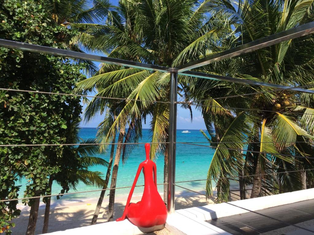 a red vase sitting on a window looking at the beach at Sundown Beach Studios in Boracay