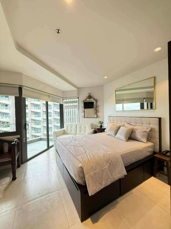 a large bedroom with a large bed and a mirror at stevenplace at Tambuli in Maribago