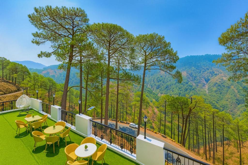 a view from the balcony of a resort with tables and chairs at Hotel Ambience Hill Nainital - near Bhowali in Nainital