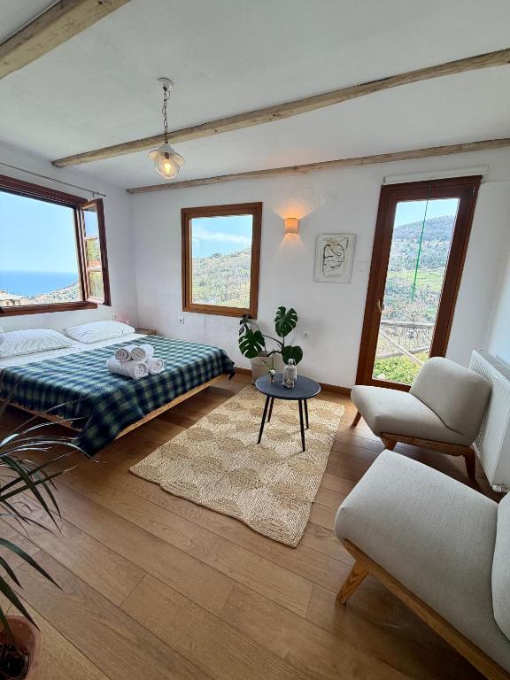a bedroom with a bed and a couch and a table at Apple Orchard Pelion in Volos
