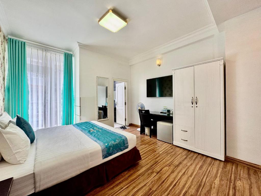 a bedroom with a bed and a desk in a room at Dalat Eco Hotel in Da Lat