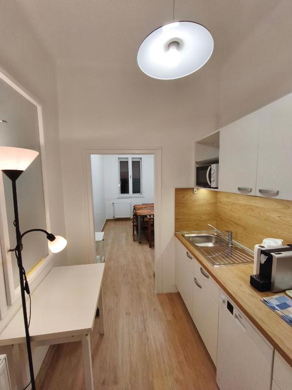 a kitchen with a white counter and a table at Toldi 5 Apartman in Pécs