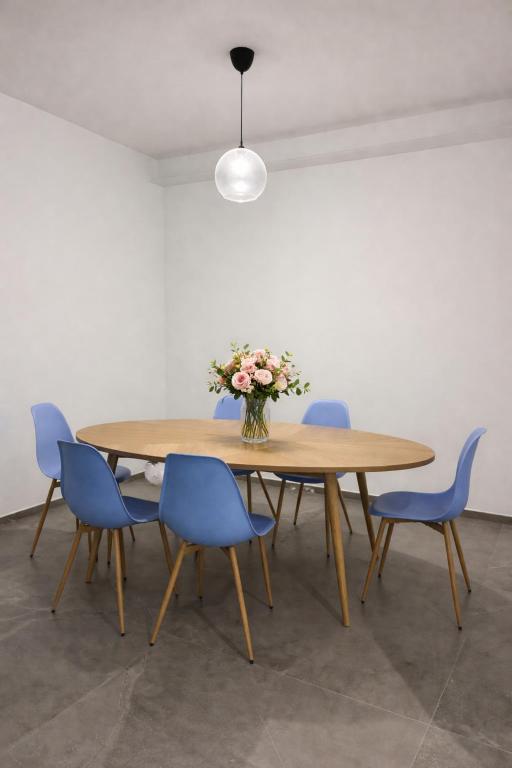 a table with blue chairs and a vase of flowers at Biancamilla's Home in Giulianova