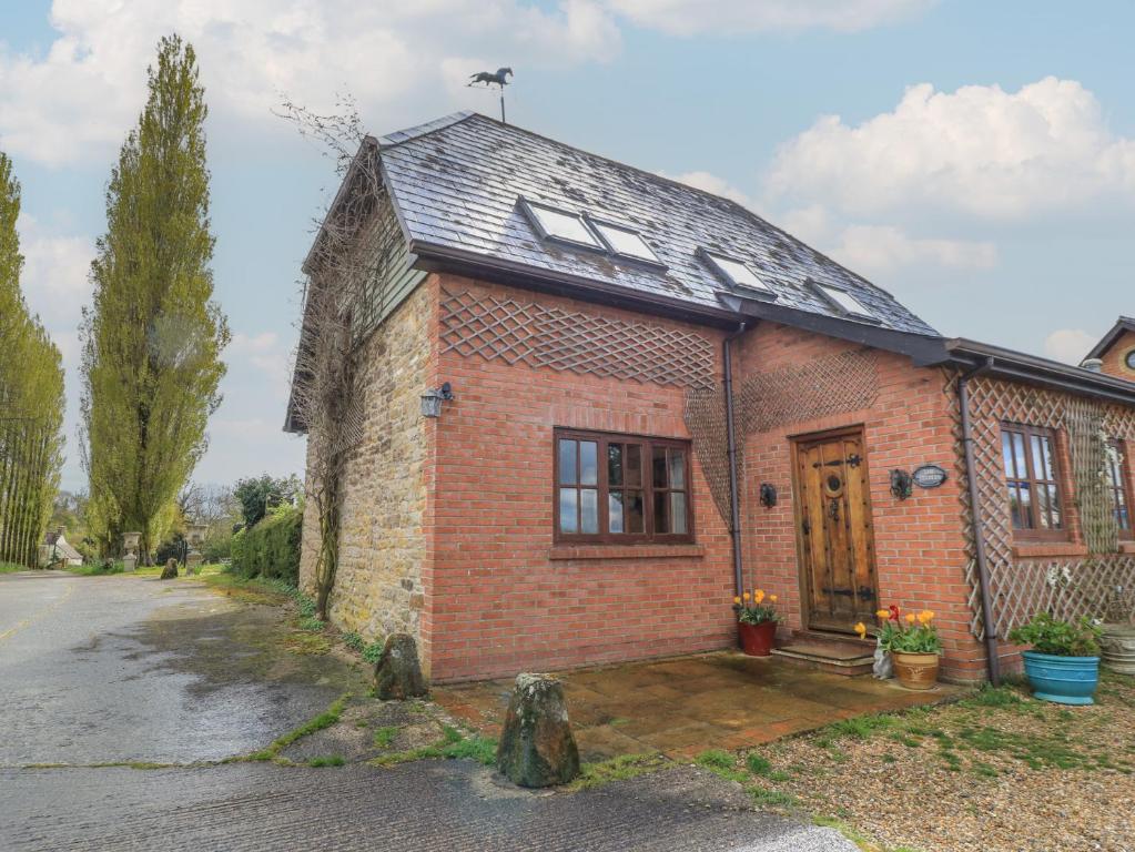 a brick house with a door on a street at The Stables in Sturminster Newton