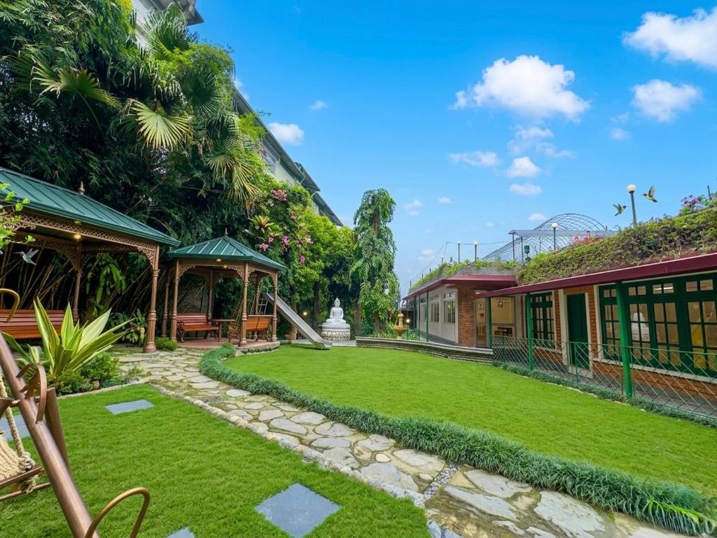a garden in front of a building with a lawn at The Garden Courtyard in Kalimpong