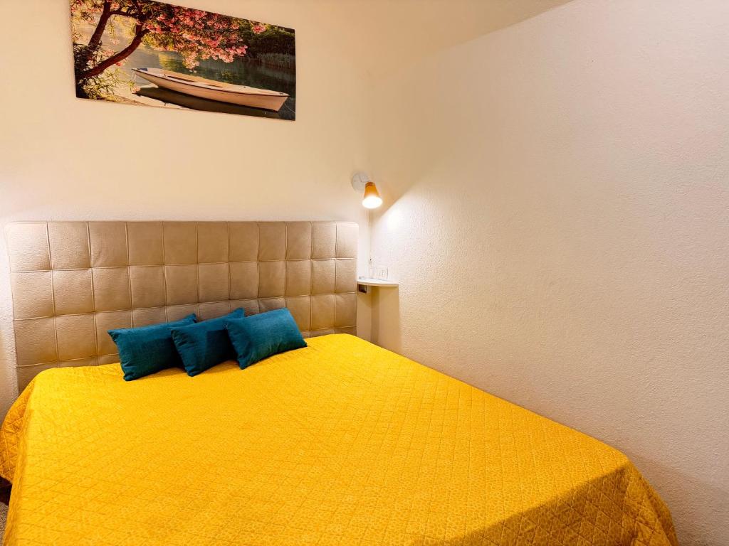 a bedroom with a yellow bed with blue pillows at Perla Del Borgo in Gallipoli