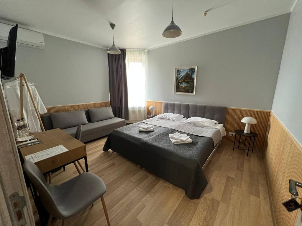 a bedroom with a bed and a couch at Guest House Uzhgorod in Uzhhorod