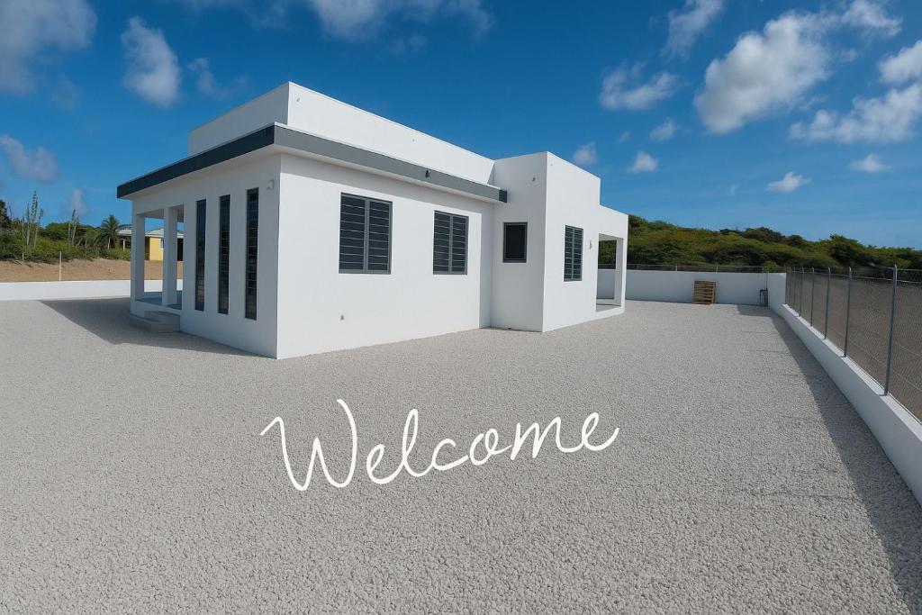 a white house with welcome written on the ground at Casa Trankilo in Fontein