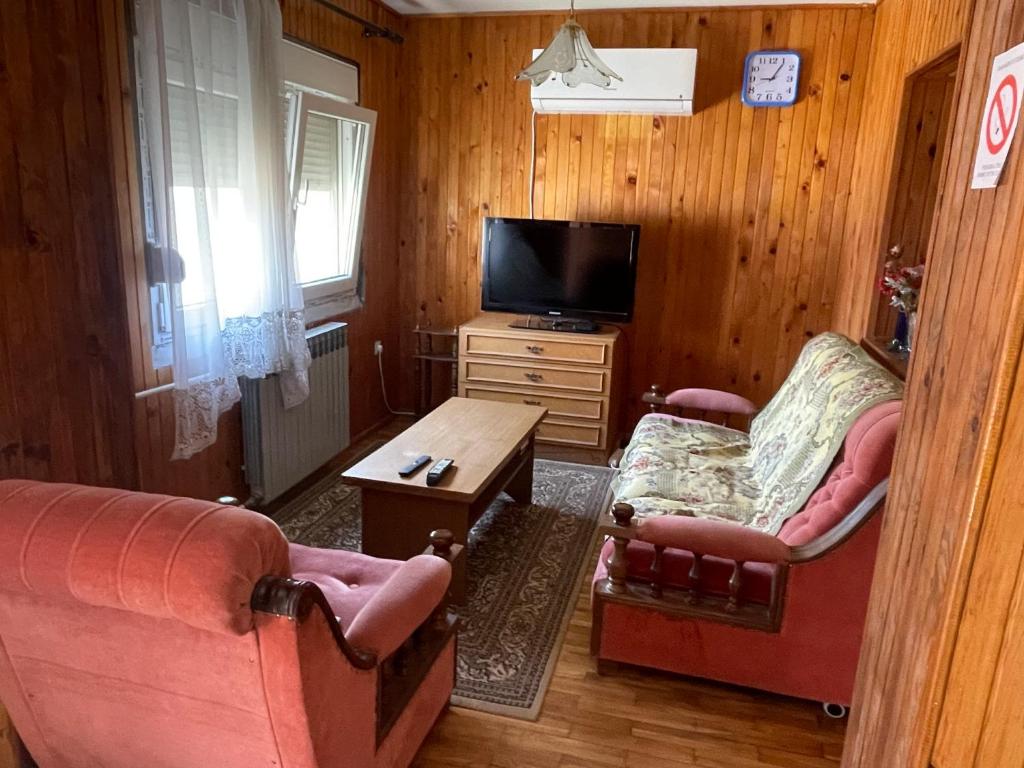 a living room with two chairs and a flat screen tv at Yellow House in Ritopek