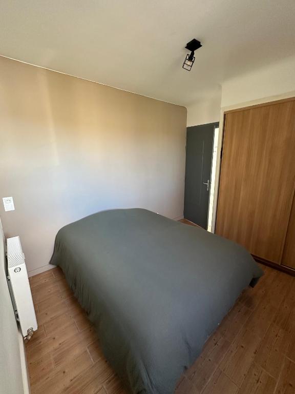 a bedroom with a large bed and a wooden floor at Maison les Boites in La Chapelle-Rousselin