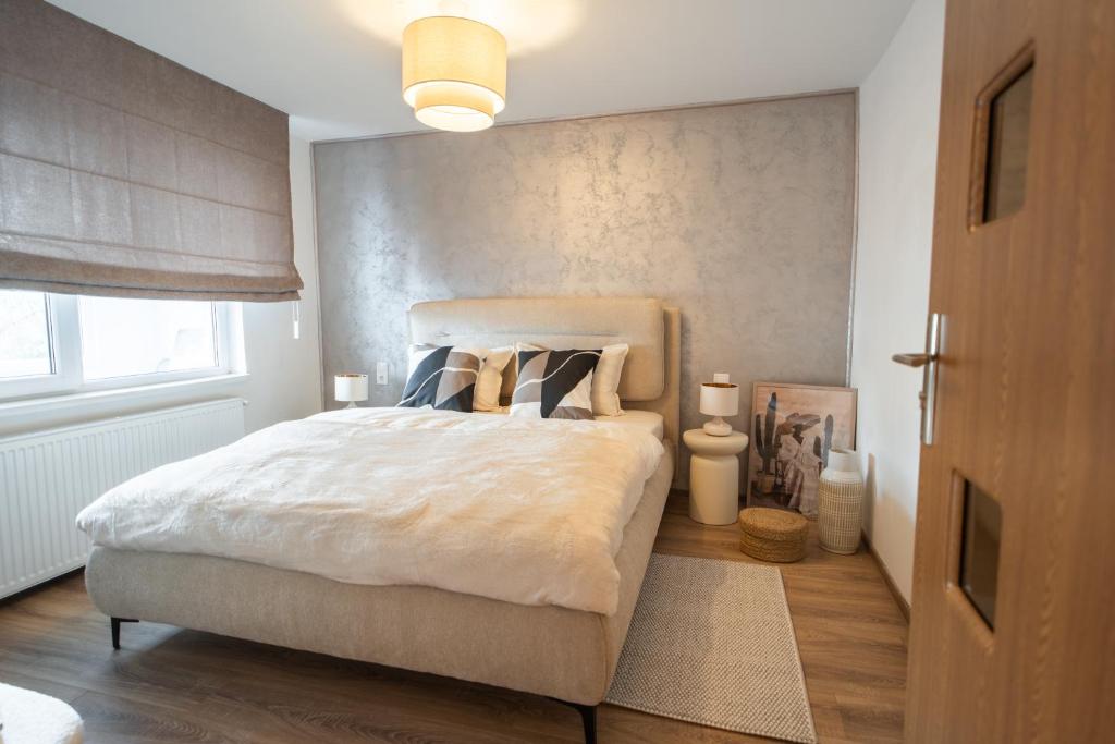 a bedroom with a large white bed and a window at Ovideli Apartment in Ocna-Mureşului