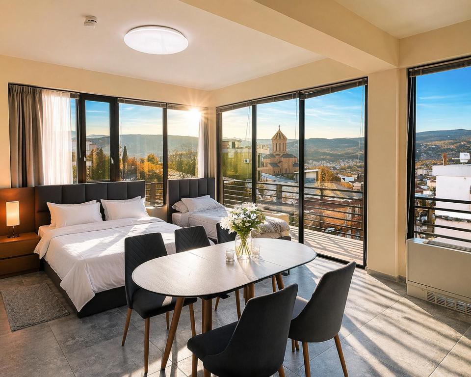 a bedroom with a bed and a table and chairs at Apartment Natali Inn in Tbilisi City