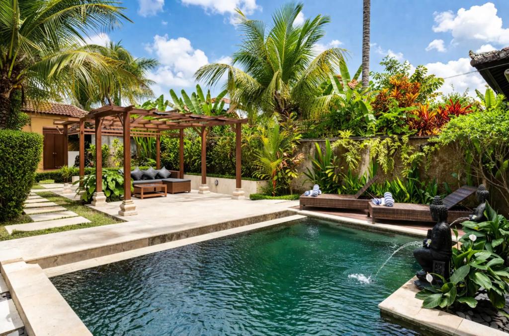 a swimming pool in a backyard with a gazebo at Villa Kami Ubud in Ubud