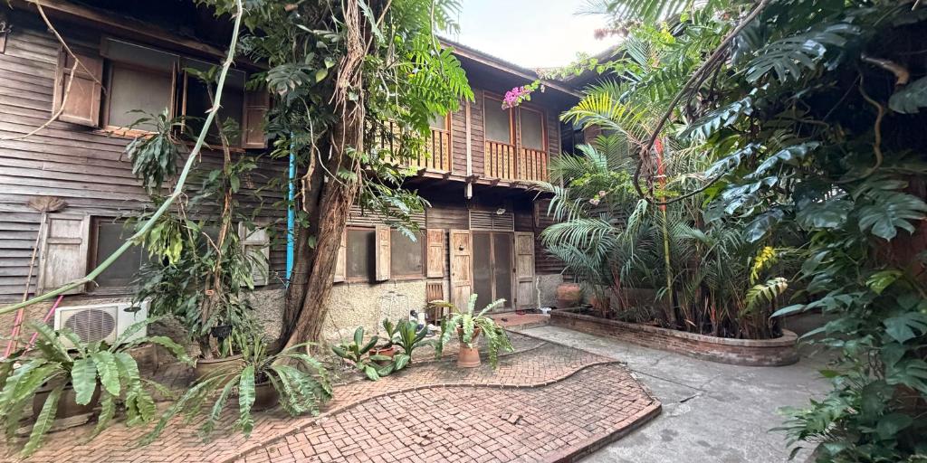 an outside view of a house with trees and plants at Villa Guesthouse Bangkok in Bangkok