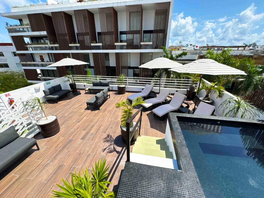 a patio with chairs and umbrellas next to a building at BORÉNA Hotel Boutique in Playa del Carmen