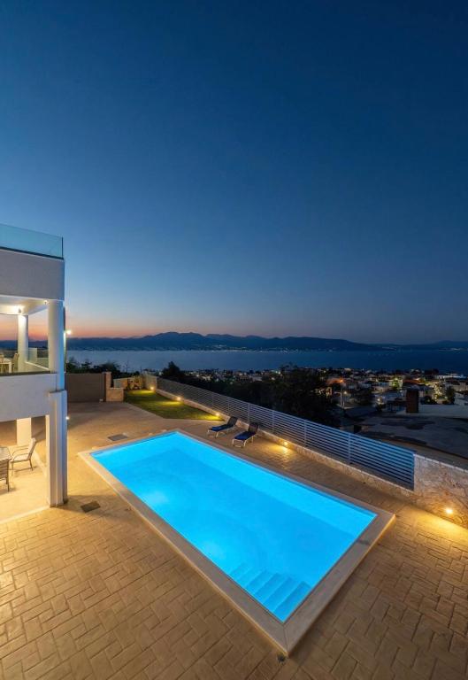 a swimming pool on the roof of a house at night at Serenitas in Kalamos
