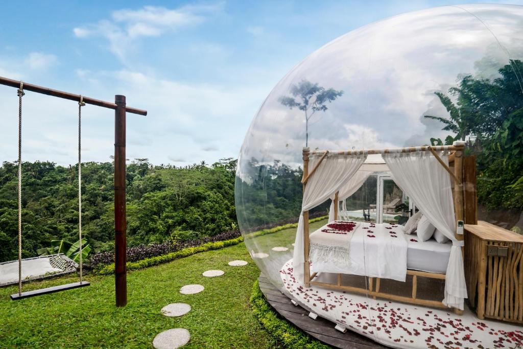 a bed in a bubble tent in a garden at Bubble 6 - Romantic Bath Bubble Stay Ubud in Tampaksiring