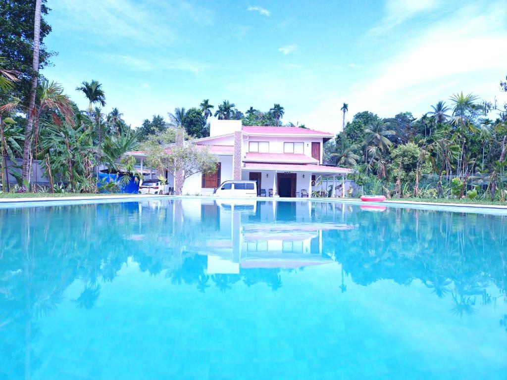 a swimming pool in front of a house at Villa Paddy Breeze in Galle