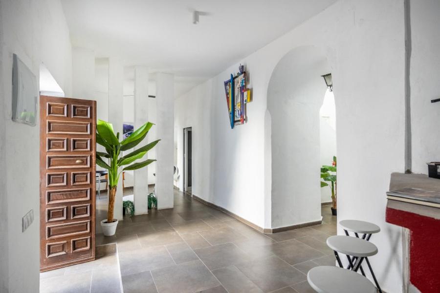 a hallway with white walls and a table and chairs at Casa Privada in Vejer de la Frontera