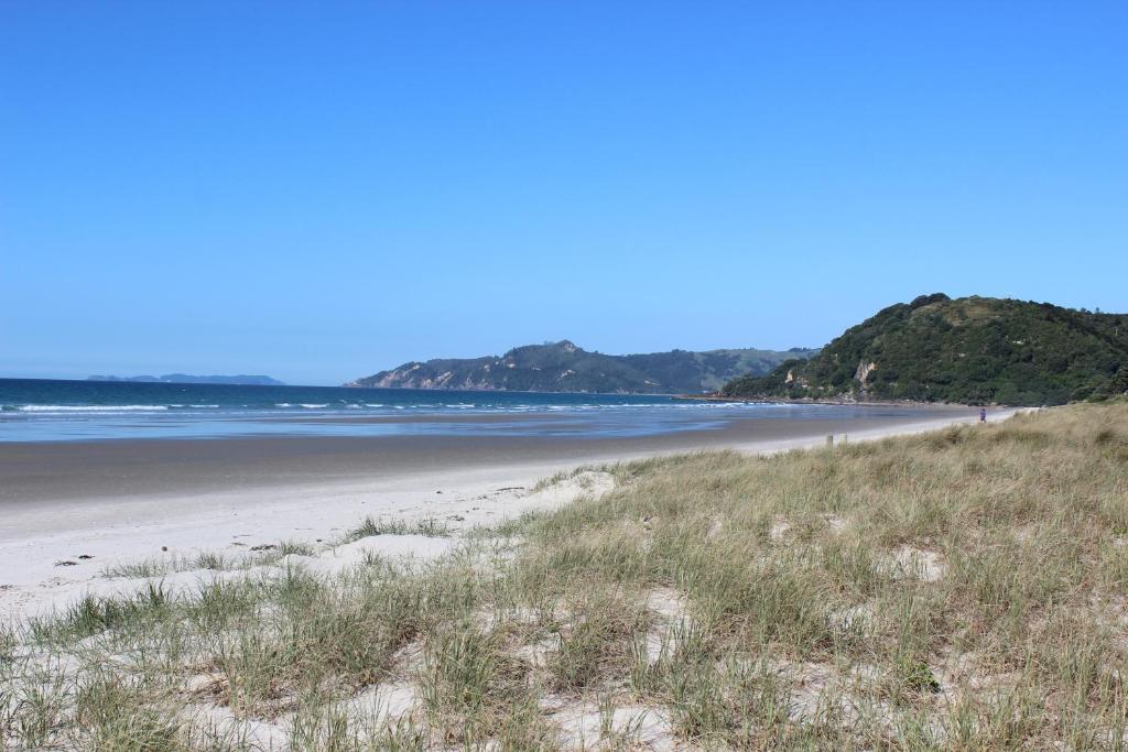 a view of a beach with mountains in the background at Sea Breezes in Matarangi