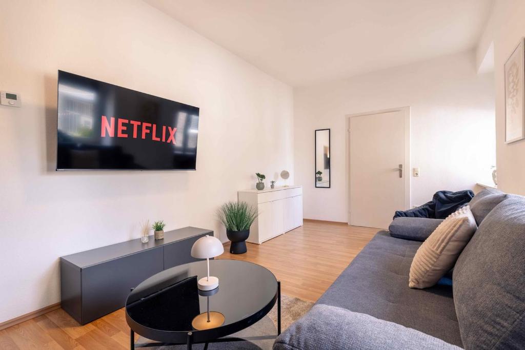 a living room with a couch and a tv on the wall at Laacher-Loft Ferienwohnung in Mendig