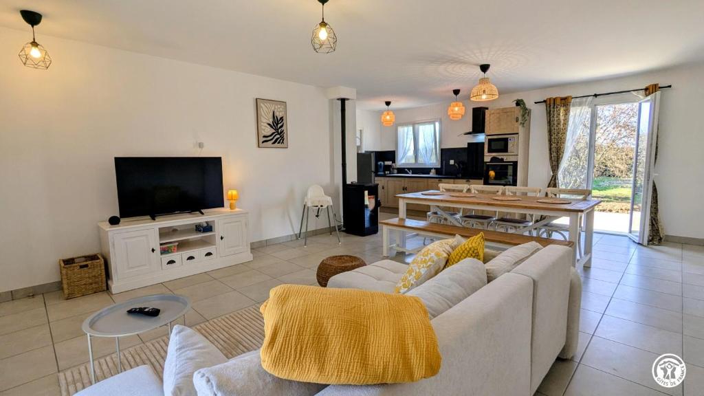 a living room with a couch and a tv at Le Refuge de Coccinette in Essey