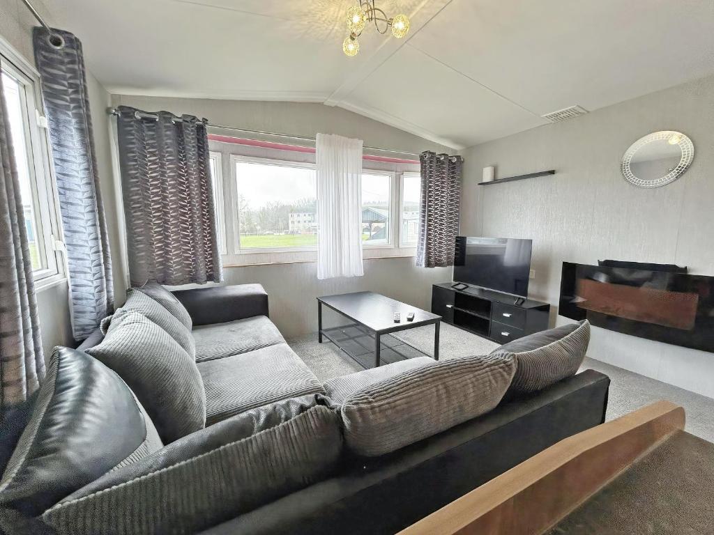 a living room with a couch and a television at The Rowan - Uk51410 in Brechin