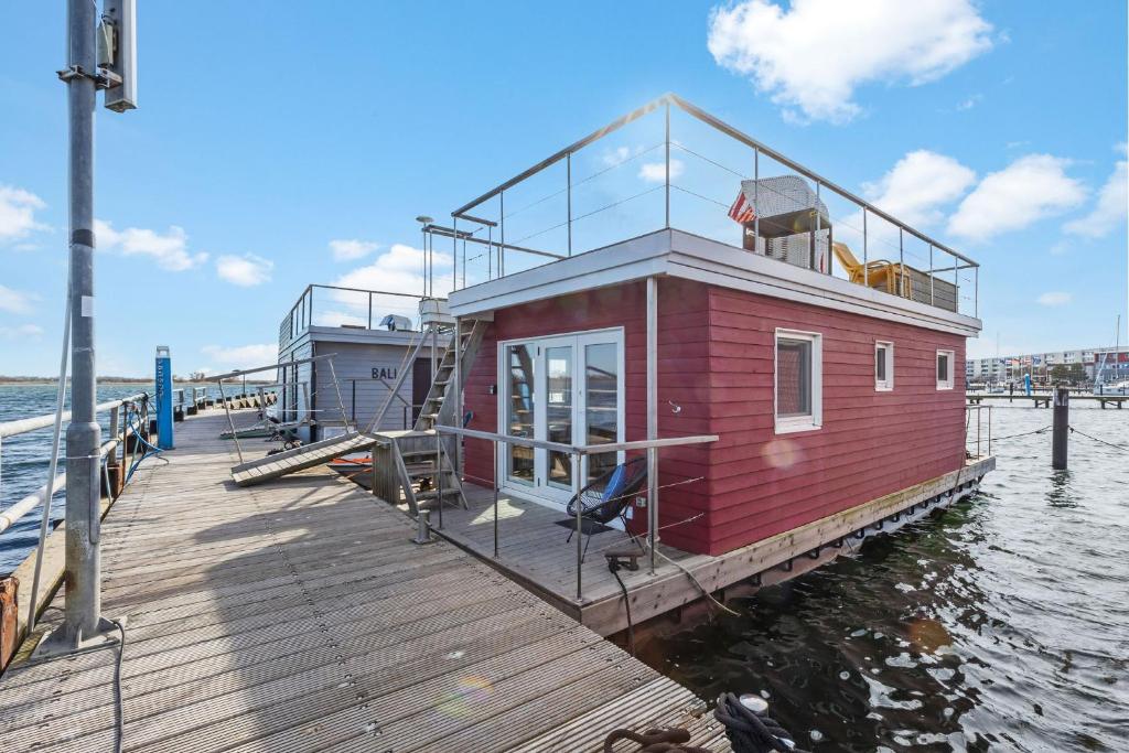 a small house on a dock on the water at Hausboot "Mien Schipp" mit Sonnendeck im Yachthafen in Fehmarn