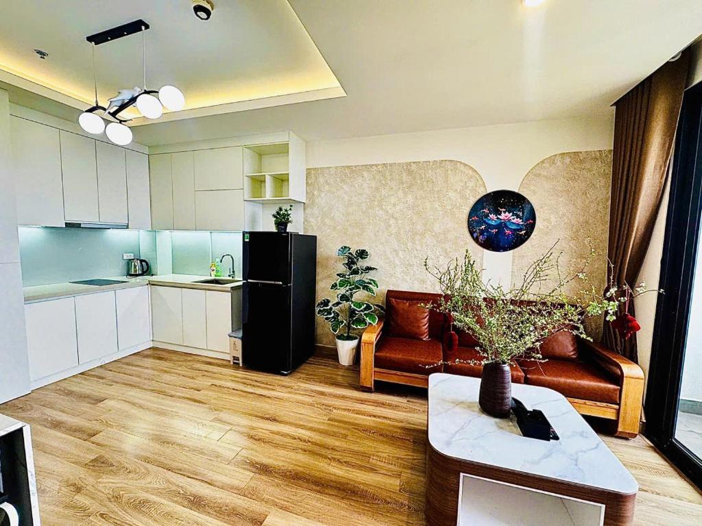 a living room with a couch a table and a kitchen at Jade's House Sapa - Stunning Views, 3BR, Kitchen & Washer, 5 Min to Town in Lao Cai